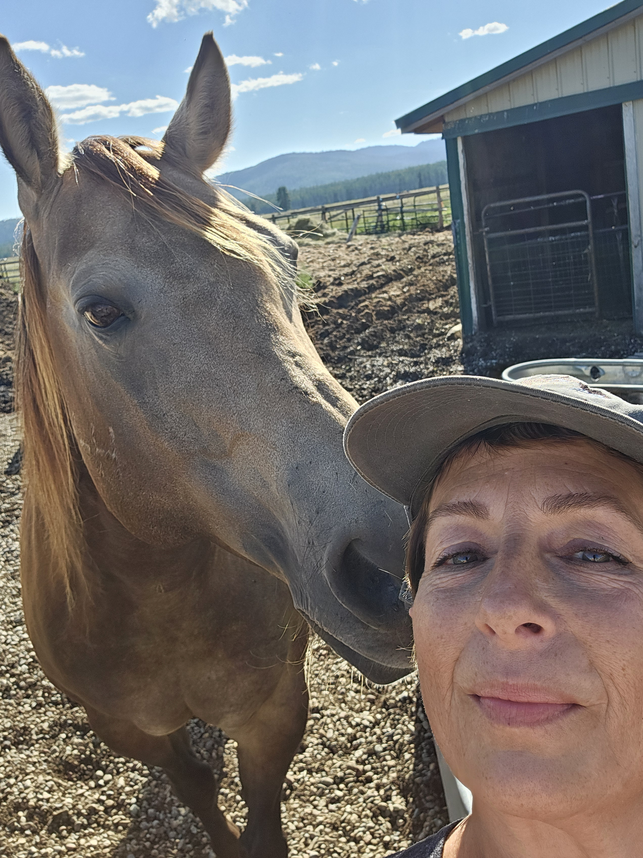 Selfie image of Rebecca with her brown horse, Gunner, looking over her shoulder.